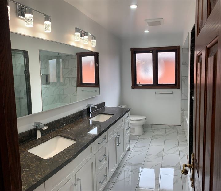 Full bathroom renovation with long vanity, quartz top and porcelain floor
